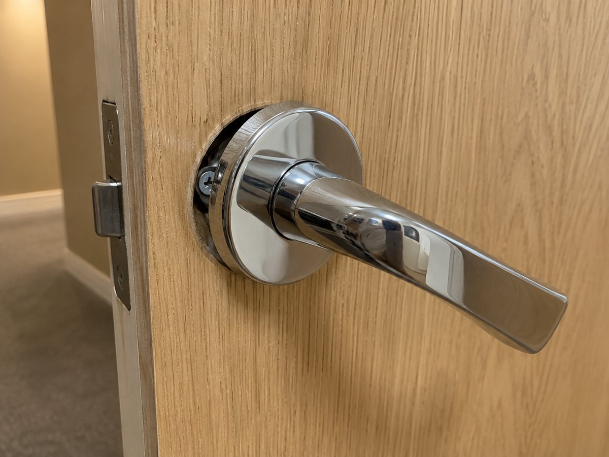 Photo d’illustration : rosace d’une poignée de porte desserrée.